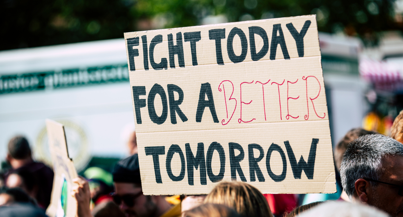 URGE header image that shows a protestors sign that reads "Fight for a Better Tomorrow"