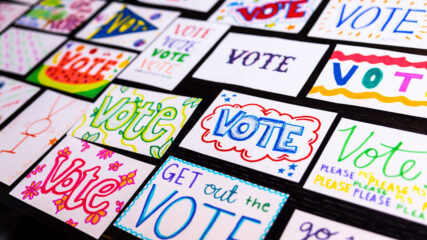 A table of postcards that say vote.