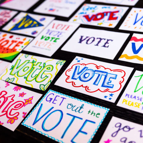 A table of postcards that say vote.