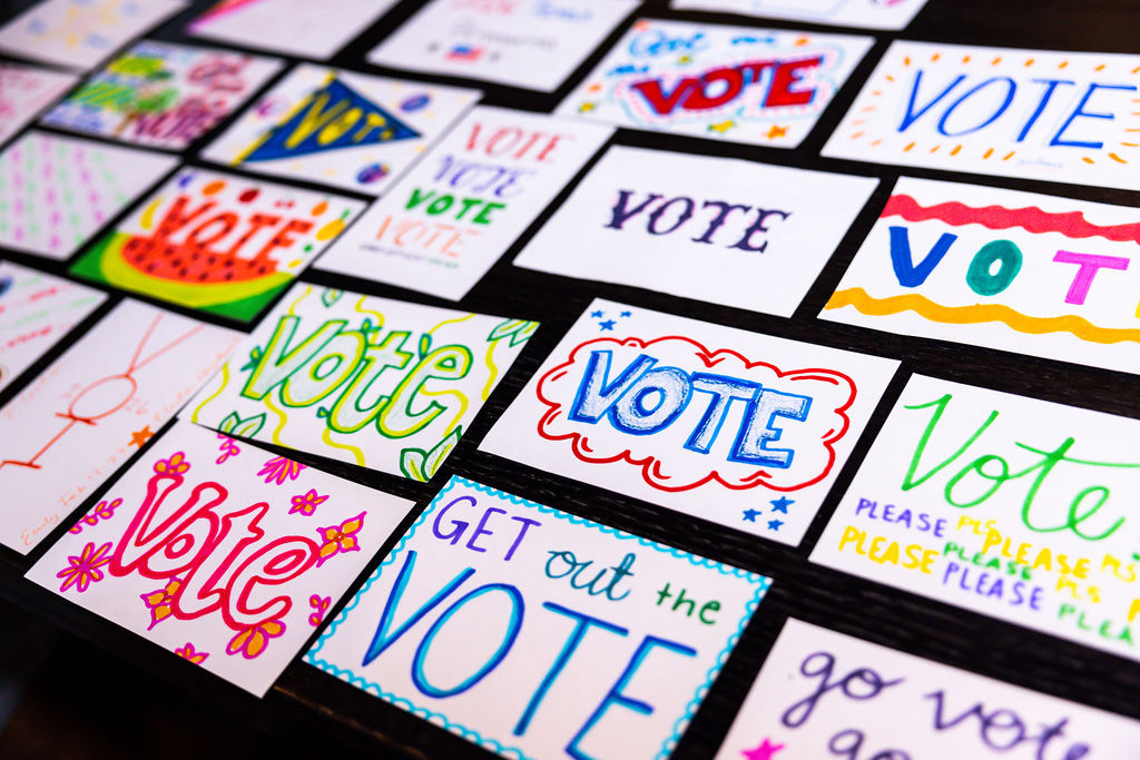 A table of postcards that say vote.